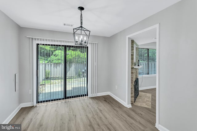 18721 Paprika Ct, Germantown, MD 20874 - unfurnished dining area with wood finished floors and a chandelier