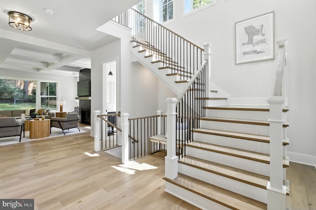 8202 Mockingbird Dr, Annandale, VA 22003 - stairs with coffered ceiling, wood finished floors, healthy amount of natural light, beamed ceiling, and a glass covered fireplace