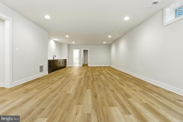 8202 Mockingbird Dr, Annandale, VA 22003 - unfurnished living room with bar with sink, recessed lighting, and light wood-type flooring