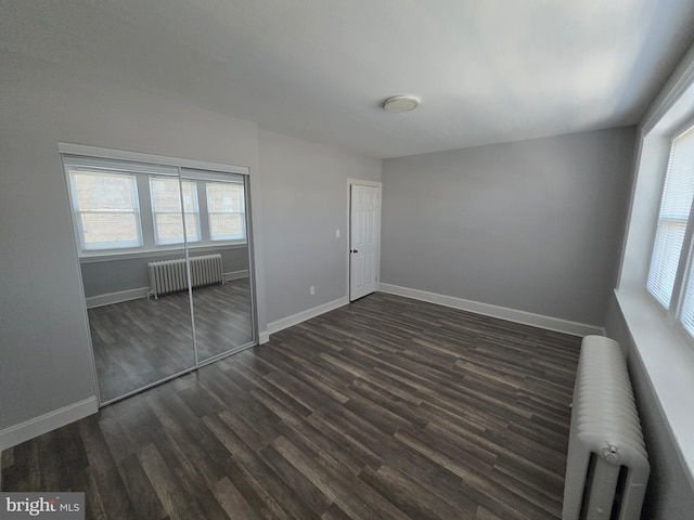 4735 Frankford Ave, Philadelphia, PA 19124 - unfurnished bedroom with radiator, multiple windows, and dark wood-type flooring