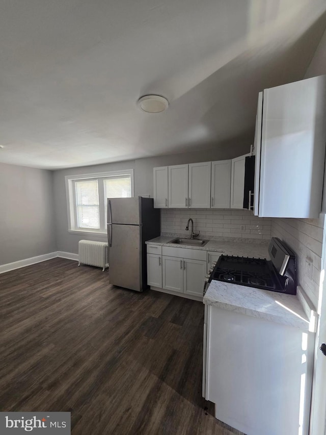 4735 Frankford Ave, Philadelphia, PA 19124 - kitchen featuring freestanding refrigerator, radiator, range with gas cooktop, dark wood finished floors, and decorative backsplash