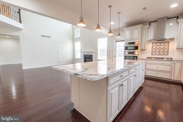 4251 Beech Dr, Nazareth, PA 18064 - kitchen featuring wall chimney exhaust hood, appliances with stainless steel finishes, open floor plan, dark wood finished floors, and tasteful backsplash