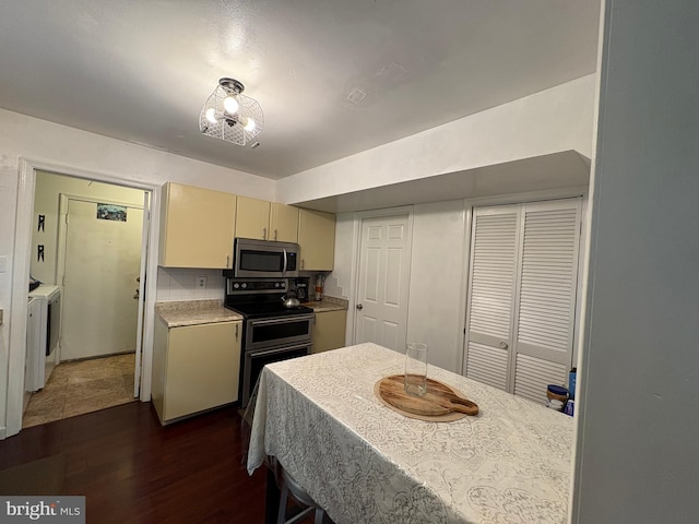 4105 Sunburst Ct, Alexandria, VA 22303 - kitchen with stainless steel appliances, washing machine and dryer, dark wood-style flooring, light countertops, and cream cabinets