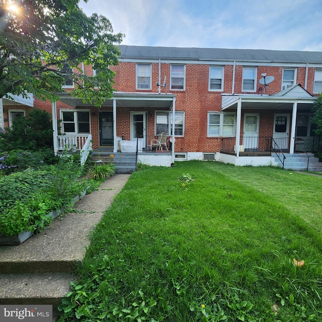 3648 Benson Ave, Baltimore, MD 21227 - townhome / multi-family property featuring a porch, brick siding, and a front yard