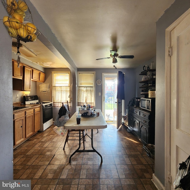 3648 Benson Ave, Baltimore, MD 21227 - kitchen with white range with gas cooktop, a ceiling fan, and brick patterned flooring