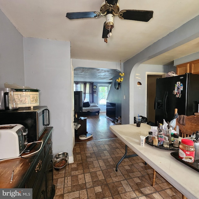 3648 Benson Ave, Baltimore, MD 21227 - kitchen with black appliances, arched walkways, brick patterned flooring, and ceiling fan