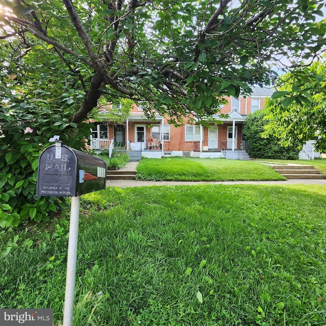 3648 Benson Ave, Baltimore, MD 21227 - view of property hidden behind natural elements with brick siding, covered porch, and a front lawn