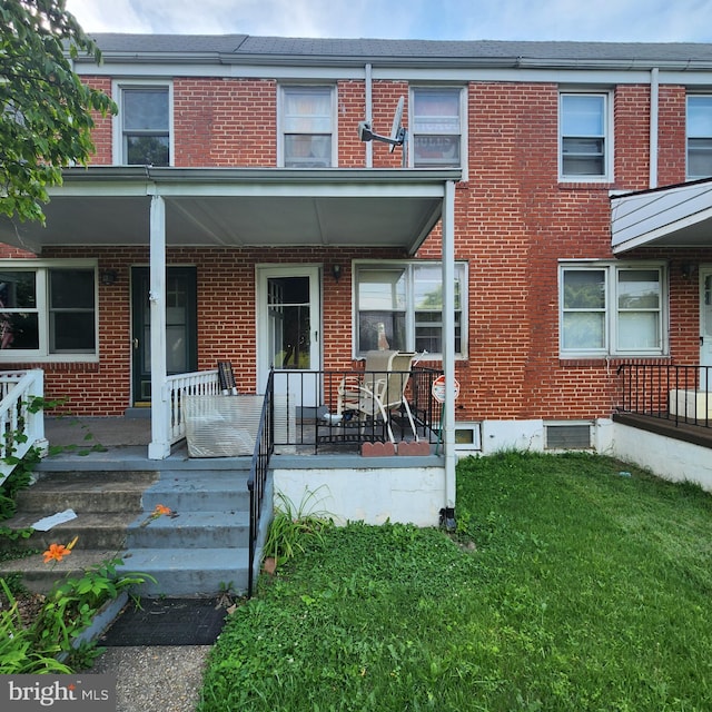 3648 Benson Ave, Baltimore, MD 21227 - view of front of property featuring covered porch, brick siding, and a front yard