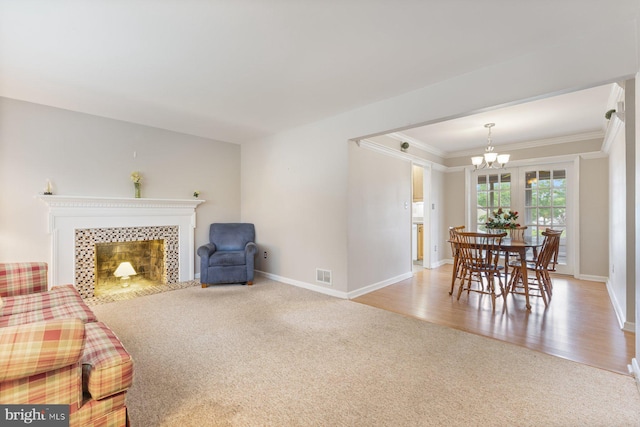 12703 Bluhill Rd, Silver Spring, MD 20906 - living room featuring a chandelier, crown molding, light carpet, a tiled fireplace, and light wood-type flooring