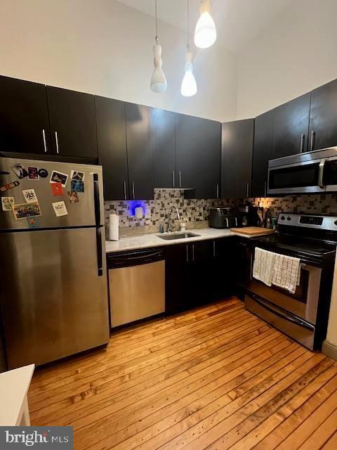 511 S Bond St Unit 304, Baltimore, MD 21231 - kitchen featuring appliances with stainless steel finishes, dark cabinets, light countertops, tasteful backsplash, and a towering ceiling