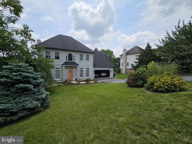 1012 Woodridge Rd, Red Lion, PA 17356 - view of front of home with an attached garage, a front yard, asphalt driveway, and a chimney