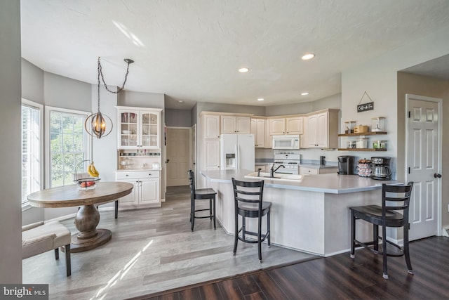 1012 Woodridge Rd, Red Lion, PA 17356 - kitchen featuring white appliances, dark wood-style floors, a peninsula, a kitchen bar, and recessed lighting
