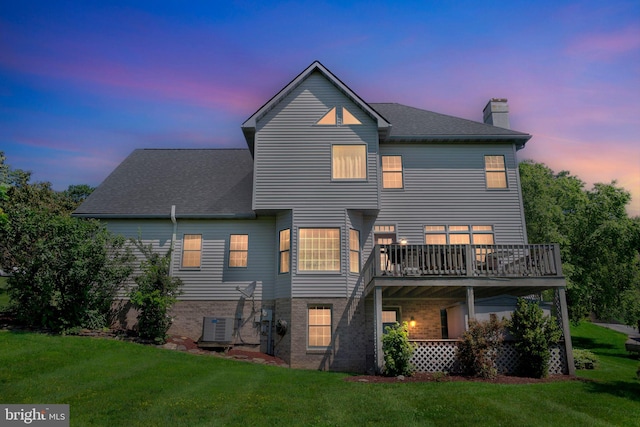 1012 Woodridge Rd, Red Lion, PA 17356 - back of house at dusk with a chimney, a lawn, a shingled roof, and brick siding