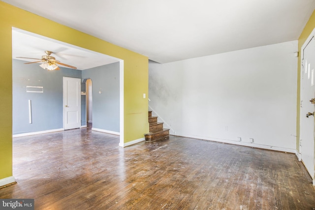 627 Forrester St SE, Washington, DC 20032 - empty room featuring a ceiling fan, stairs, wood finished floors, and arched walkways