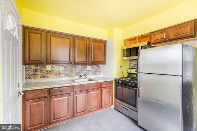 627 Forrester St SE, Washington, DC 20032 - kitchen with appliances with stainless steel finishes, light countertops, tasteful backsplash, and brown cabinets