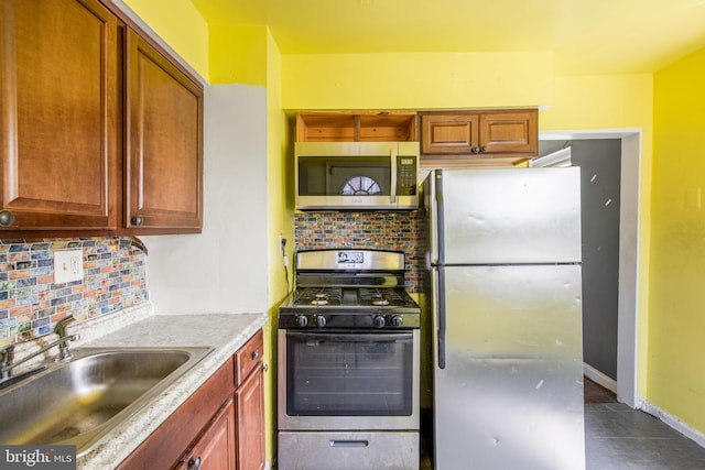 627 Forrester St SE, Washington, DC 20032 - kitchen with appliances with stainless steel finishes, tasteful backsplash, and dark tile patterned floors