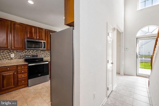 12 Juniper Ct Unit 63, Millville, DE 19967 - kitchen with stainless steel appliances, light tile patterned flooring, decorative backsplash, light stone counters, and recessed lighting