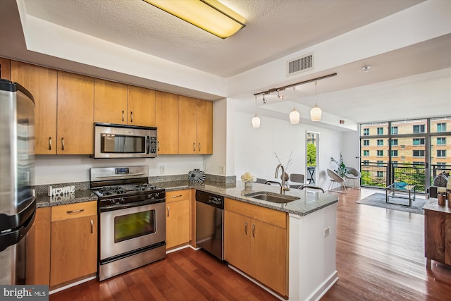 475 K St NW Unit 630, Washington, DC 20001 - kitchen with appliances with stainless steel finishes, open floor plan, a peninsula, dark stone countertops, and dark wood-style floors