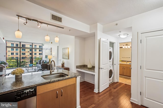 475 K St NW Unit 630, Washington, DC 20001 - kitchen featuring stacked washing machine and dryer, stainless steel dishwasher, dark wood finished floors, dark stone countertops, and pendant lighting