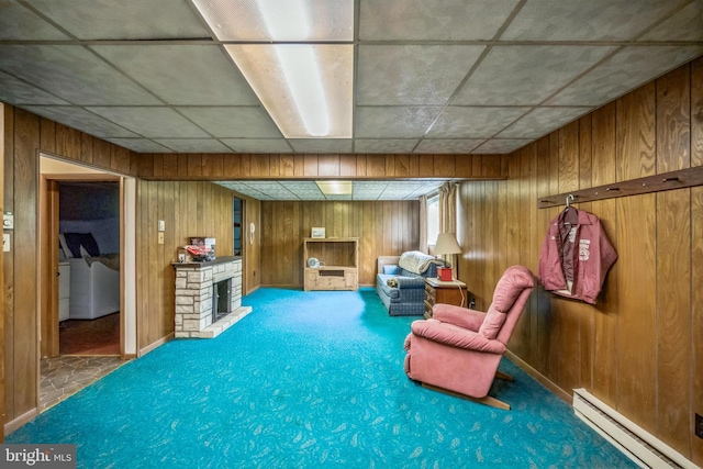 23 Maple St, Ashland, PA 17921 - sitting room with a baseboard radiator, washing machine and dryer, wooden walls, carpet flooring, and a stone fireplace