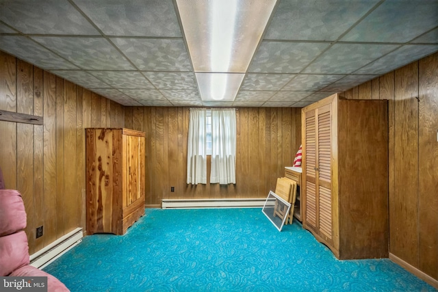 23 Maple St, Ashland, PA 17921 - below grade area featuring a baseboard heating unit, baseboard heating, carpet, wooden walls, and a paneled ceiling
