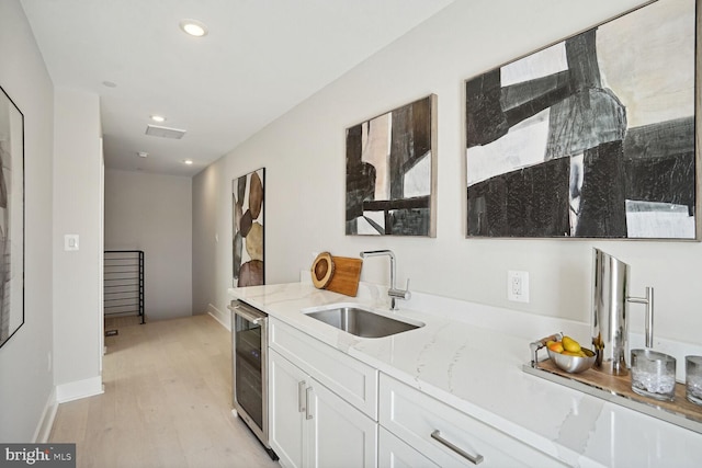 901 19th St NE Unit Ph2, Washington, DC 20002 - kitchen with wine cooler, white cabinetry, light wood-style flooring, light stone countertops, and recessed lighting