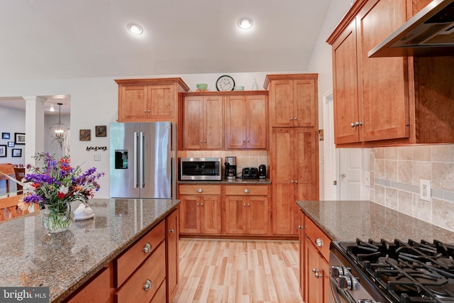 10 Elser Hill Rd, Lititz, PA 17543 - kitchen with stainless steel appliances, under cabinet range hood, brown cabinets, decorative columns, and dark stone countertops