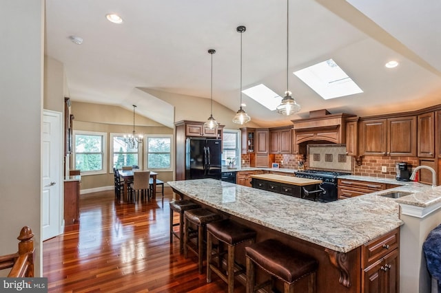240 Meadow Dr, Haddonfield, NJ 08033 - kitchen featuring black appliances, dark wood-style flooring, custom range hood, a center island, and a skylight
