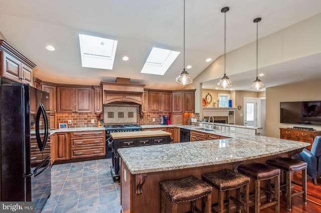240 Meadow Dr, Haddonfield, NJ 08033 - kitchen with black appliances, a skylight, custom exhaust hood, backsplash, and open floor plan