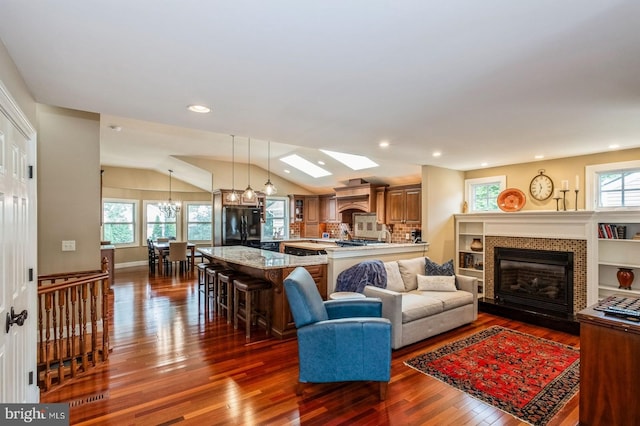 240 Meadow Dr, Haddonfield, NJ 08033 - living area featuring dark wood-style floors, a tiled fireplace, vaulted ceiling, a chandelier, and recessed lighting