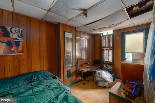 2560 W Fairmount Ave, Baltimore, MD 21223 - bedroom with wooden walls, wood finished floors, and a drop ceiling