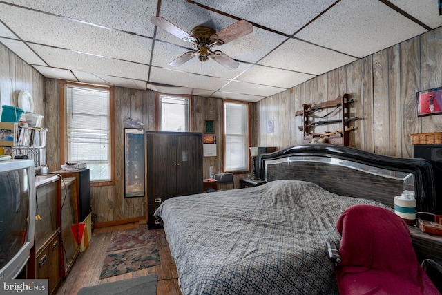 2560 W Fairmount Ave, Baltimore, MD 21223 - bedroom with wooden walls, wood-type flooring, and a drop ceiling