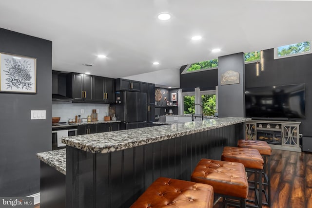 18424 Horseshoe Bend Rd, Sharpsburg, MD 21782 - kitchen featuring freestanding refrigerator, exhaust hood, stainless steel range with electric cooktop, dark cabinets, and a breakfast bar