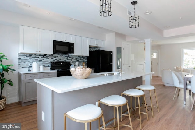 1616 C St NE, Washington, DC 20002 - kitchen with black appliances, light wood-style flooring, backsplash, light countertops, and decorative light fixtures