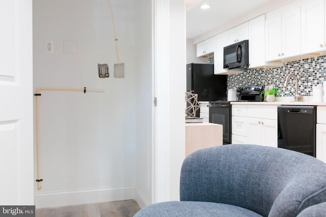 1616 C St NE, Washington, DC 20002 - kitchen with black appliances, tasteful backsplash, white cabinetry, wood finished floors, and recessed lighting
