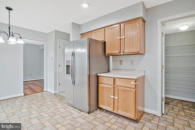 6483 Sedgwick St, Elkridge, MD 21075 - kitchen with stainless steel refrigerator with ice dispenser, a chandelier, light countertops, hanging light fixtures, and brick patterned flooring