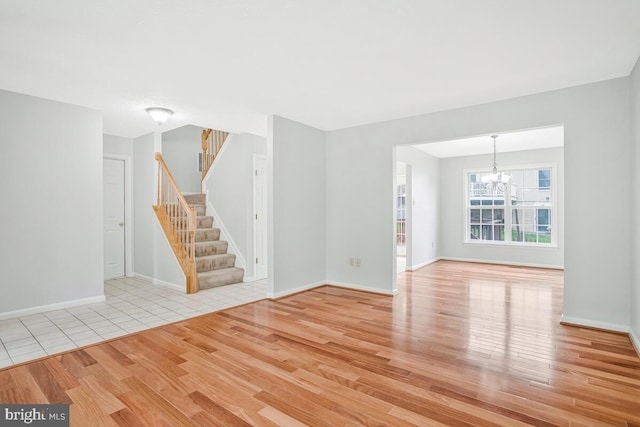 6483 Sedgwick St, Elkridge, MD 21075 - unfurnished living room with wood finished floors, a chandelier, and stairs