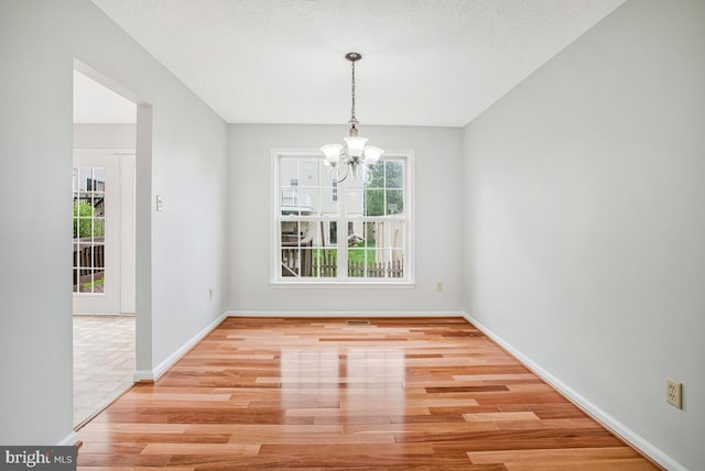 6483 Sedgwick St, Elkridge, MD 21075 - unfurnished dining area with a chandelier, plenty of natural light, and wood finished floors