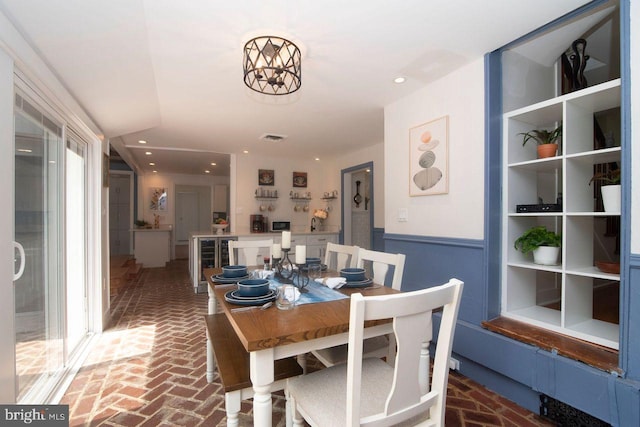716 Old Fallston Rd, Fallston, MD 21047 - dining space with brick floors, a wainscoted wall, beverage cooler, and a chandelier