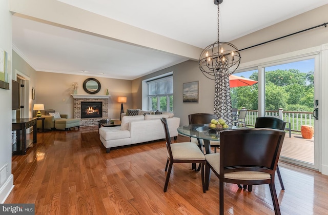 96 Becks Blvd, Ringoes, NJ 08551 - dining room with wood finished floors, a chandelier, a brick fireplace, and ornamental molding