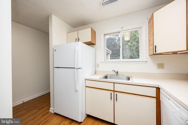 753 Canvasback Ct Unit 204, Salisbury, MD 21804 - kitchen featuring white appliances, light wood finished floors, light countertops, and a textured ceiling