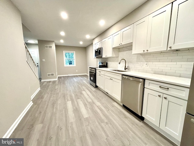 1078 Lakeview Dr, Cross Junction, VA 22625 - kitchen with appliances with stainless steel finishes, decorative backsplash, white cabinets, light wood-style floors, and light stone countertops
