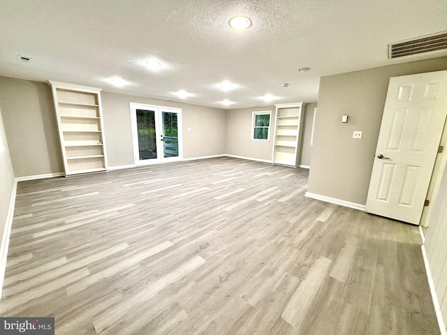 1078 Lakeview Dr, Cross Junction, VA 22625 - unfurnished living room featuring a textured ceiling, built in shelves, wood finished floors, and french doors