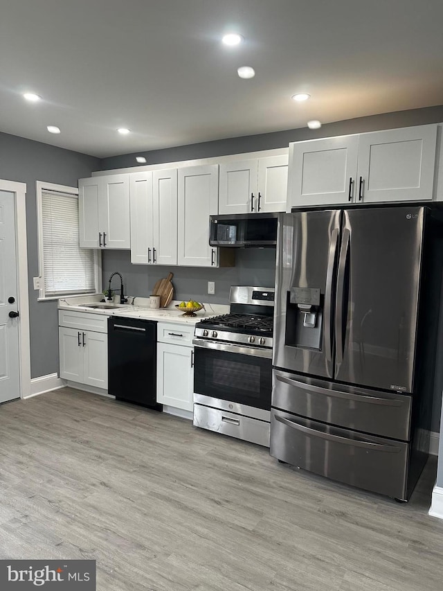 3720 Brooklyn, Baltimore, MD 21225 - kitchen featuring stainless steel appliances, light countertops, white cabinets, recessed lighting, and light wood-style flooring