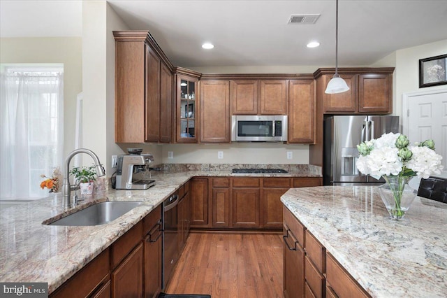 35 Gallery Rd, Stafford, VA 22554 - kitchen featuring appliances with stainless steel finishes, light stone countertops, decorative light fixtures, glass insert cabinets, and wood finished floors