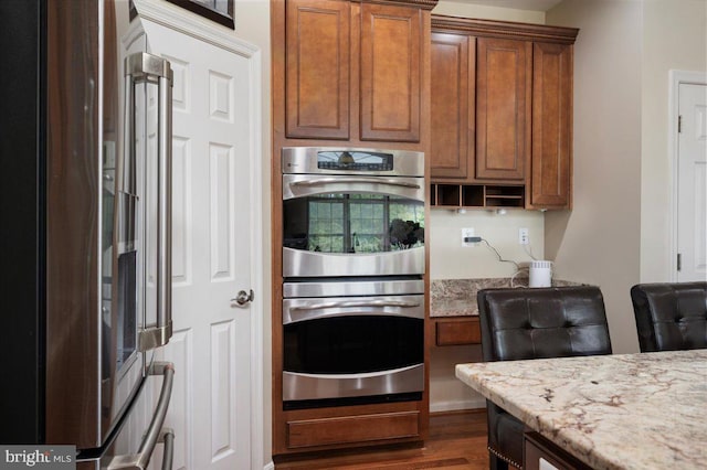 35 Gallery Rd, Stafford, VA 22554 - kitchen with appliances with stainless steel finishes, brown cabinets, dark wood finished floors, and light stone countertops
