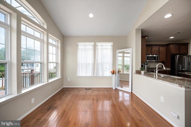 35 Gallery Rd, Stafford, VA 22554 - kitchen featuring stainless steel appliances, light wood finished floors, light stone counters, dark brown cabinets, and vaulted ceiling