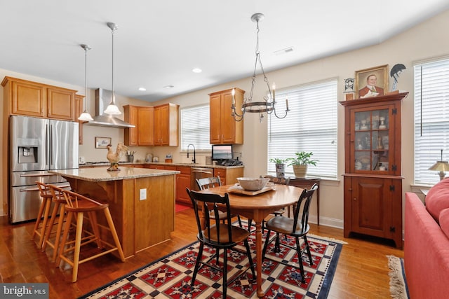 13 Doddington Blvd, Medford, NJ 08055 - kitchen featuring appliances with stainless steel finishes, wall chimney exhaust hood, a kitchen island, wood finished floors, and plenty of natural light