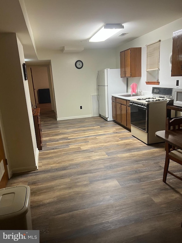 300 W New St, Glassboro, NJ 08028 - kitchen featuring white appliances, wood finished floors, brown cabinetry, and light countertops