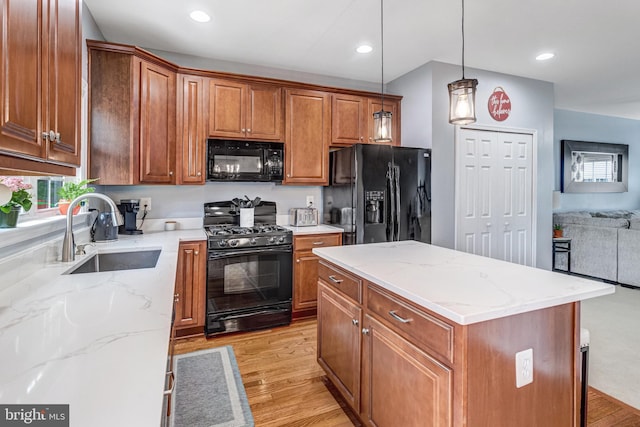 107 Pelican Cv, Stafford, VA 22554 - kitchen with black appliances, light wood-style floors, open floor plan, light stone countertops, and hanging light fixtures